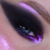 Nahaufnahme eines Auges mit dramatischem schwarzem Moonshadow Matte Pressed Eyeshadow und violettem Glitzer.