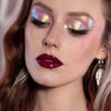 Frau mit dramatischem Eyeliner und glänzenden dunkelroten Lippen trägt rosa-gold schimmernden Opal Moonstone Loose Multichrome Eyeshadow in Boujee Bae auf den Augen.