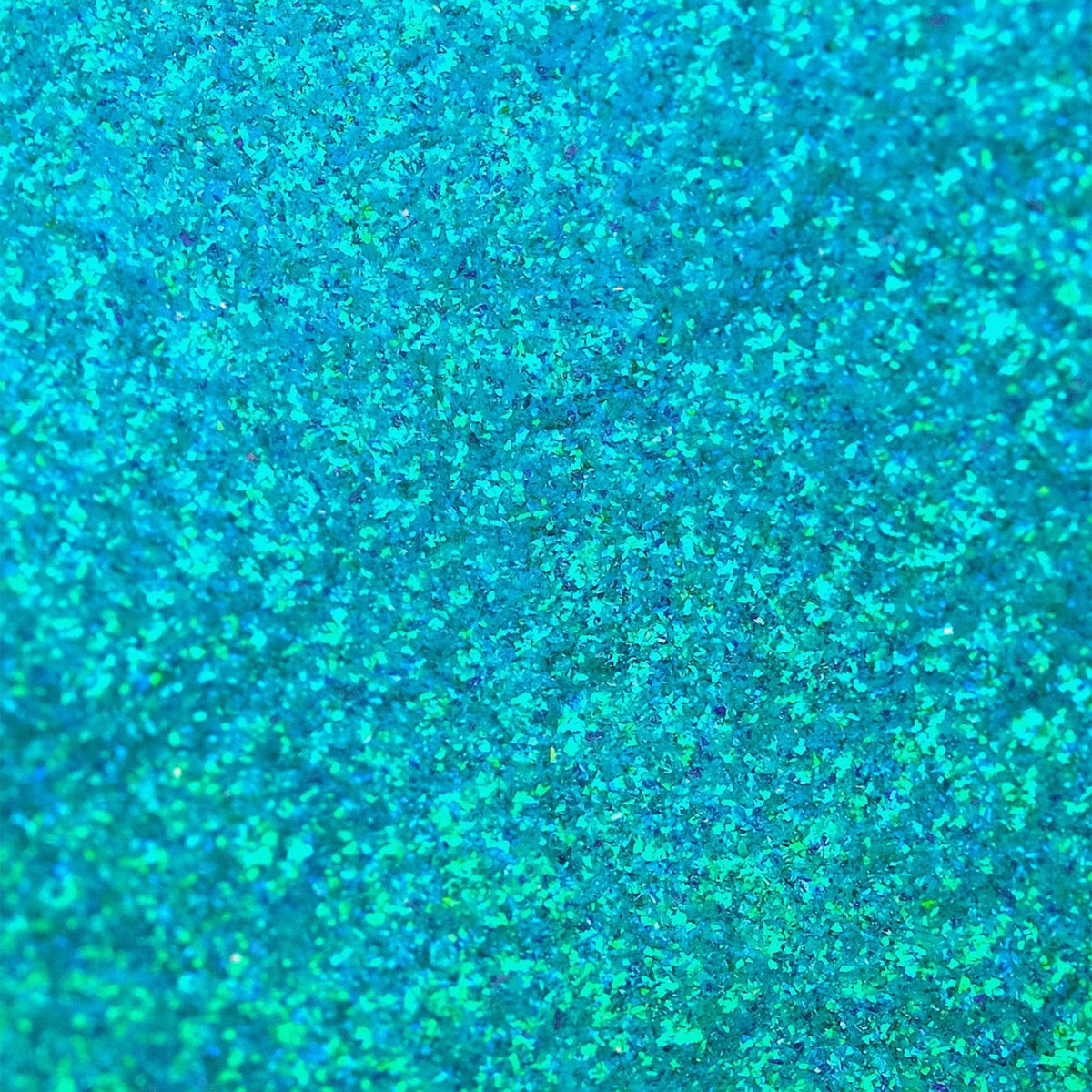 Nahaufnahme der Textur des des Opal Moonstone Loose Multichrome Eyeshadow Clever Clogs; ein türkis schimmerndes Pigment.