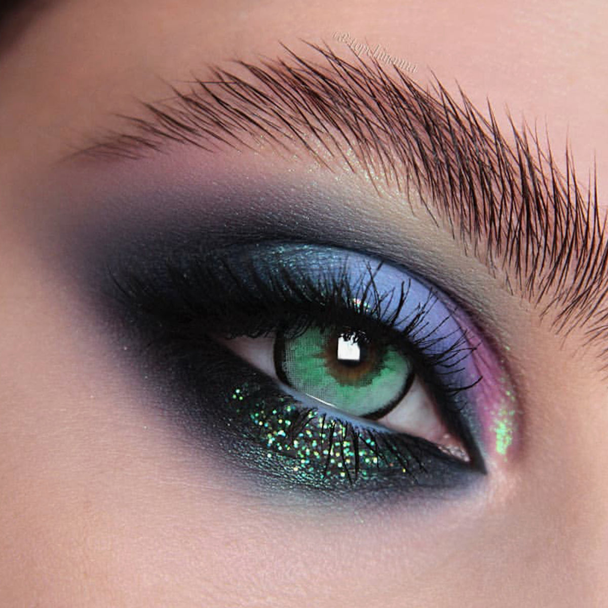 Nahaufnahme eines Auges mit dramatischem Eyeliner und grünlich-blau schimmerndem Opal Multichrome Loose Eyeshadow in Sweetdreams.