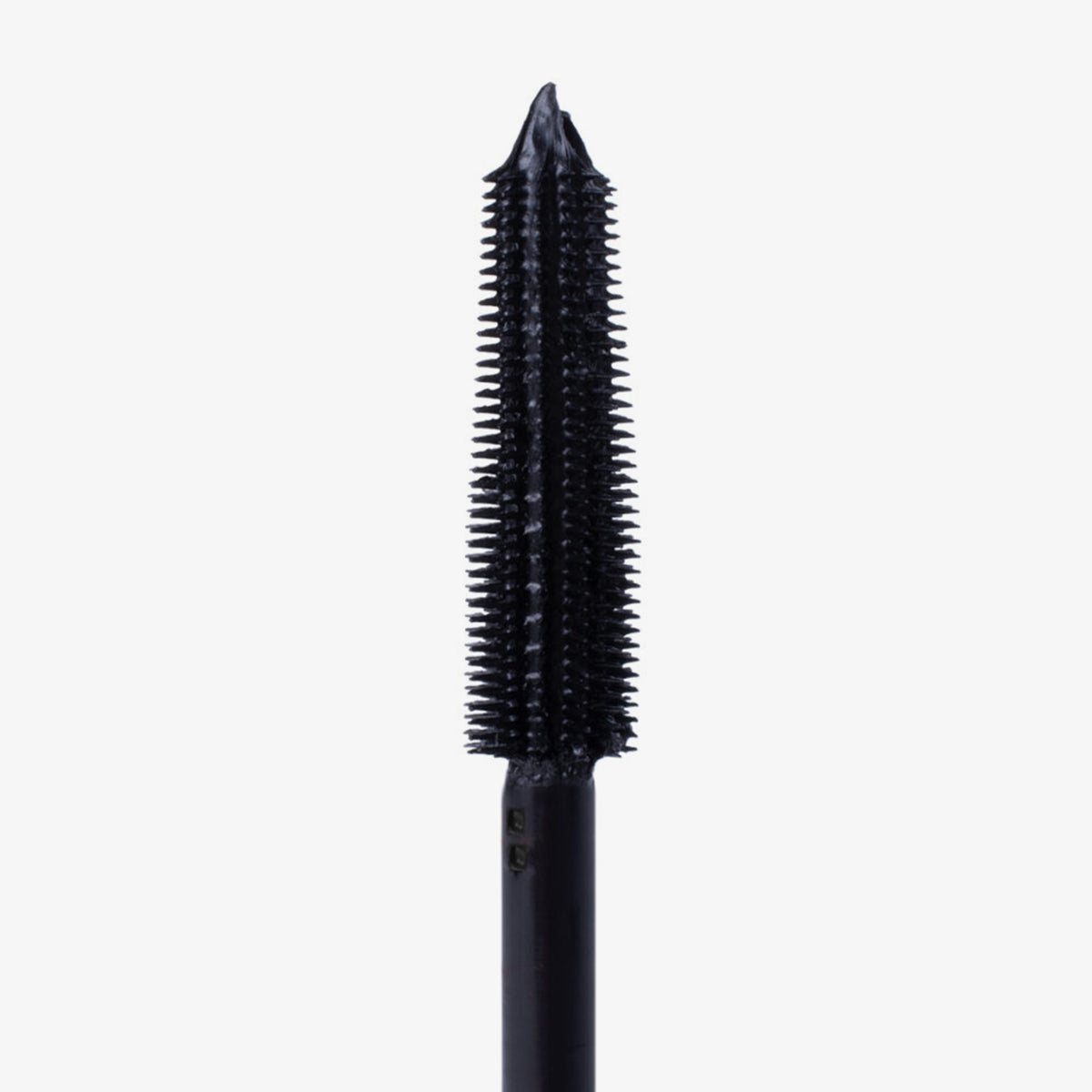 Nahaufnahme einer schwarzen Mascara-Bürste mit kurzen, dichten Borsten und spitz zulaufender Spitze vor weißem Hintergrund.