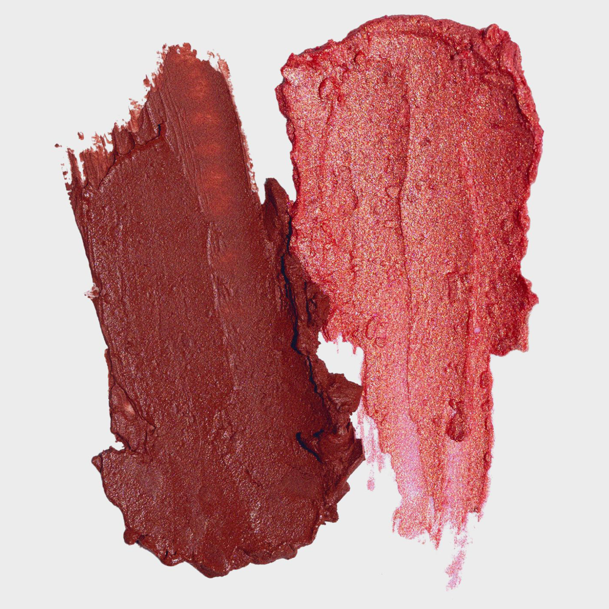 Zwei Striche von LH Cosmetics Artistick Blush, ein mattes und ein schimmerndes Rot, nebeneinander auf weißem Hintergrund.