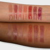 Auf zwei Unterarmen sind Farbmuster von sieben Lippenstiftfarben von LH Cosmetics Fantastick zu sehen: Topaz, Pink Opal, Rosa, Sunstone, Poppy, Goldstone und Berry.