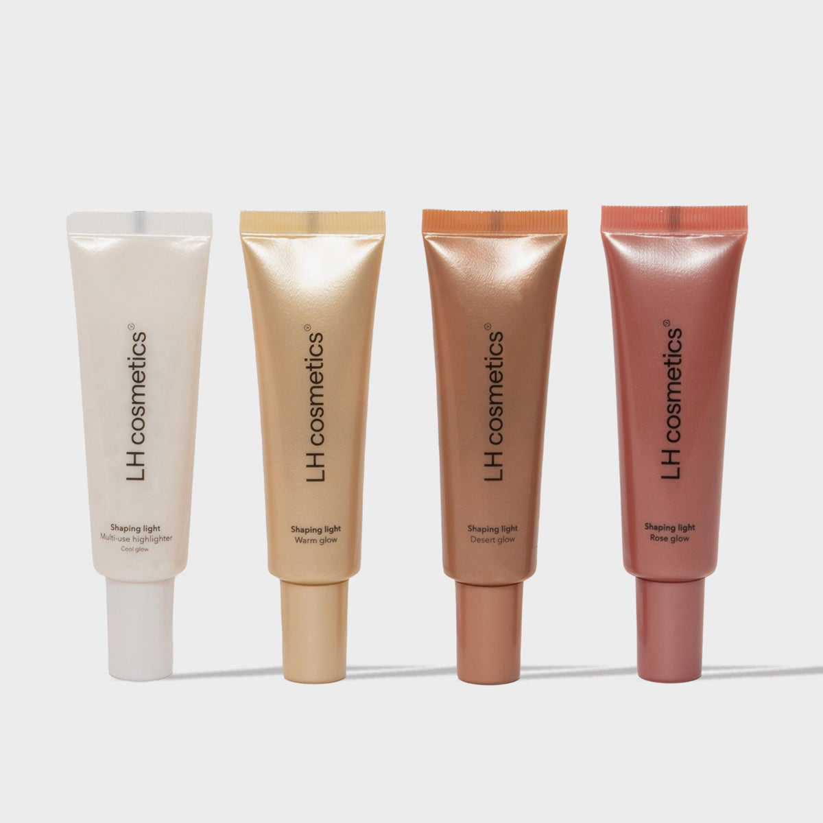 Vier LH Cosmetics Shaping Light-Röhren – Weiß, Gold, Bronze und Rosé – stehen aufrecht vor einem hellen Hintergrund.