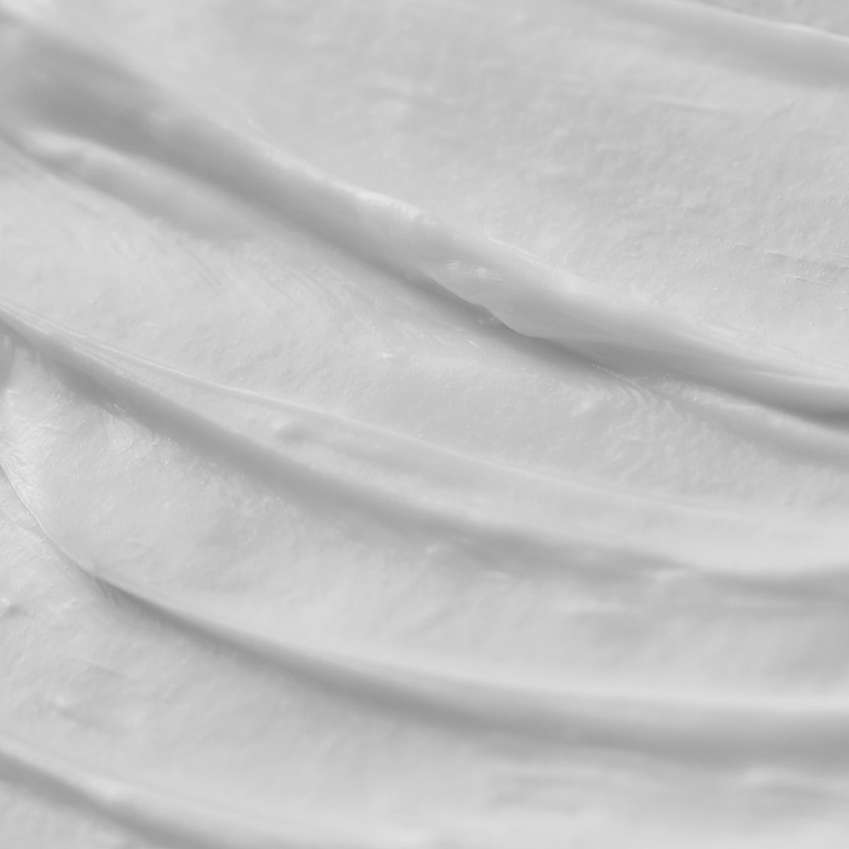 Die geschmeidige weiße Creme der Living Proof Restore Repair Mask verteilt auf einer Oberfläche.