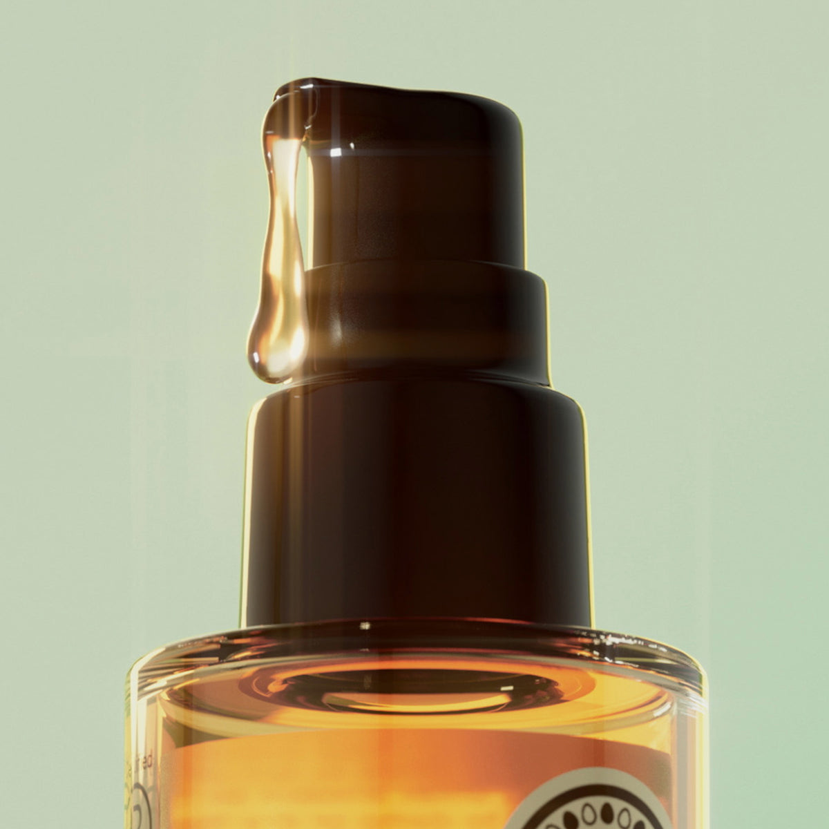 Nahaufnahme des maria nila Healing Cica Oil, das aus einer Pumpflasche mit goldener Flüssigkeit vor einem hellgrünen Hintergrund abgegeben wird.
