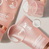 Mehrere rosa Tuben der Medicube Collagen Night Wrapping Mask mit schwebenden Tropfen auf hellem Hintergrund.
