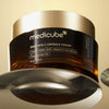 Ein Tiegel Deep Vita C Capsule Cream mit goldenem Deckel wird vor einem warmen beigen Hintergrund präsentiert.