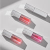 Drei Tuben Mesauda Beauty LIPOILOGY™ Lipgloss in verschiedenen Tönen und ein geschlossenes Etui, angeordnet auf einer hellen Fläche mit Schattierungen.