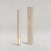 Beiger Lidschatten-Stift mit goldener Kappe von NABLA neben der passenden beigen Umverpackung mit goldenen Designelementen auf hellem Hintergrund.