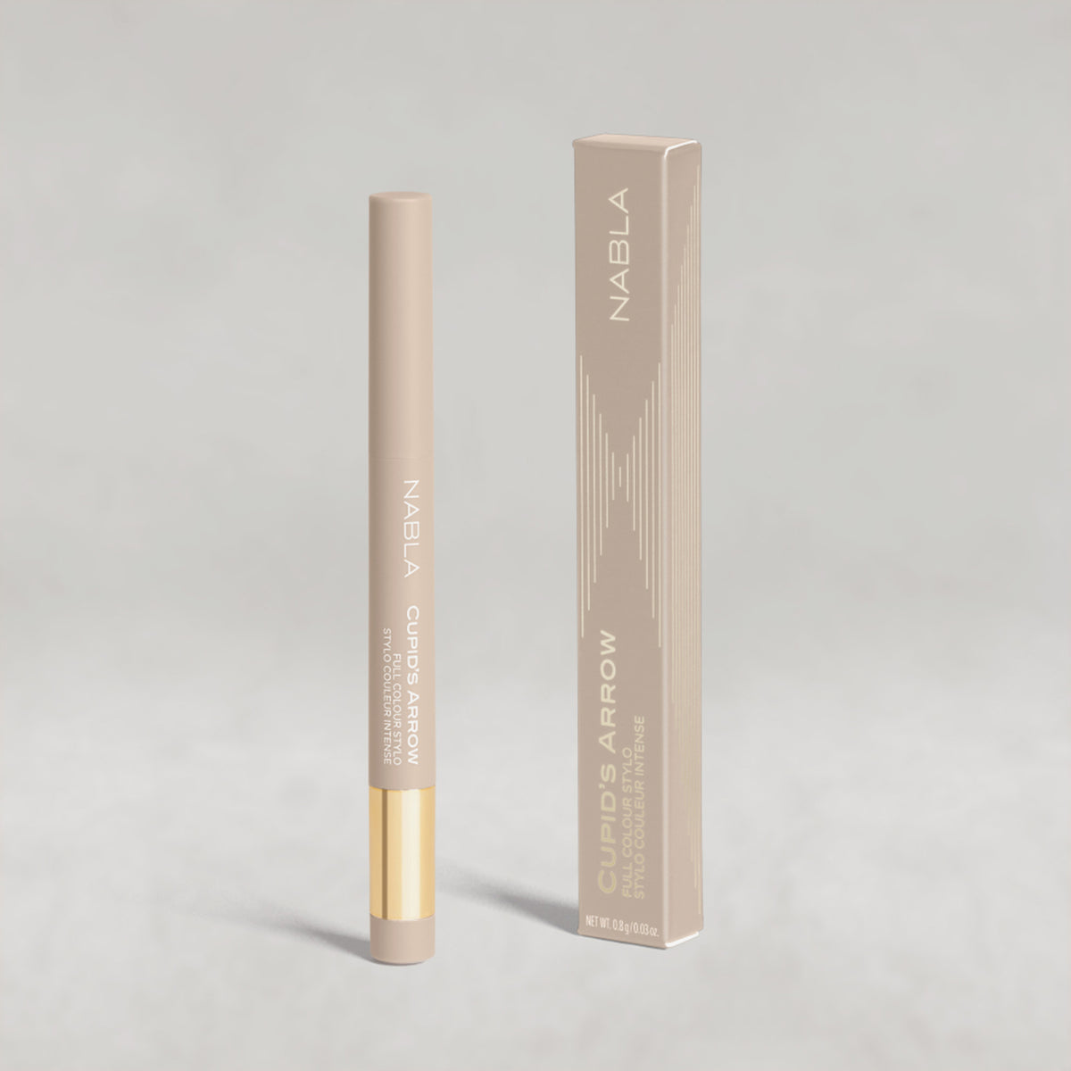 Beiger Lidschatten-Stift mit goldener Kappe von NABLA neben der passenden beigen Umverpackung mit goldenen Designelementen auf hellem Hintergrund.