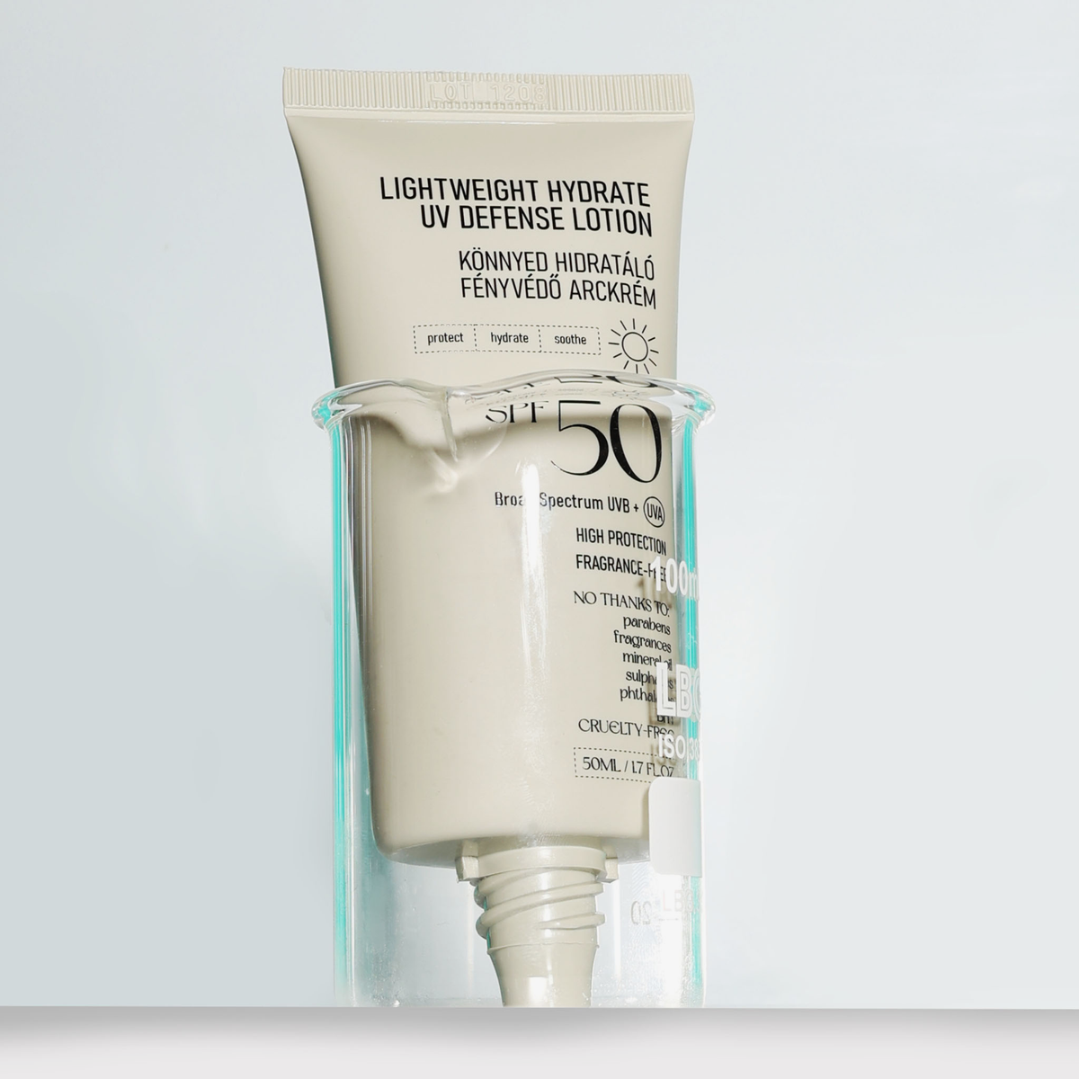 Eine Tube der NERDS. Lightweight Hydrate UV Defense Lotion SPF50 steht in einem klaren Glas vor einem hellen Hintergrund.