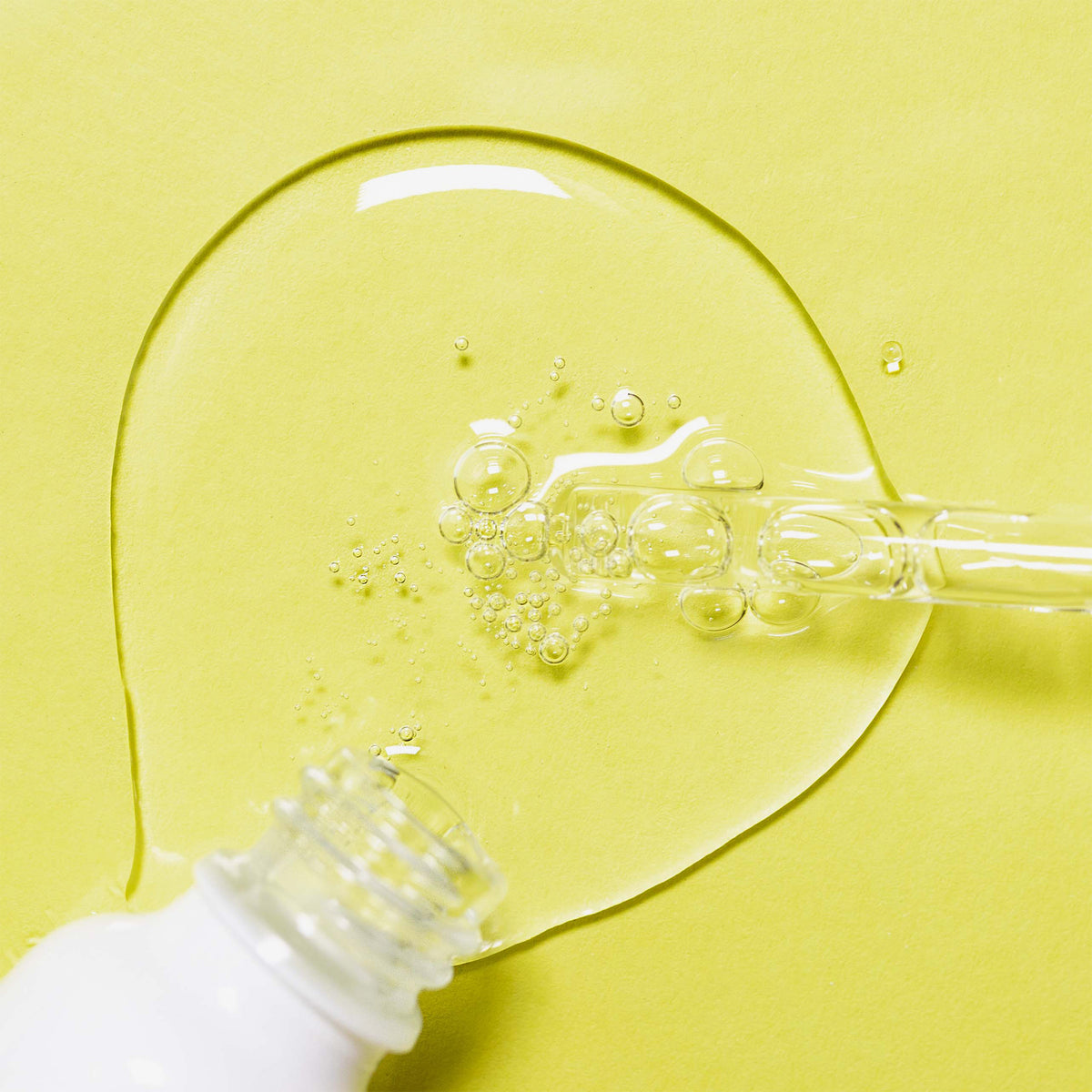 Nø Cosmetics clear tøday Chemical Peeling Serum in der weißen Flasche mit Tropfer ist ein klares, sprudelndes Serum auf gelbem Hintergrund.