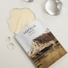 Die Madagascar Centella Watergel Sheet Ampoule Mask mit Landschaftsdesign ist teilweise aus der Verpackung gelöst und von Wassertropfen umgeben.
