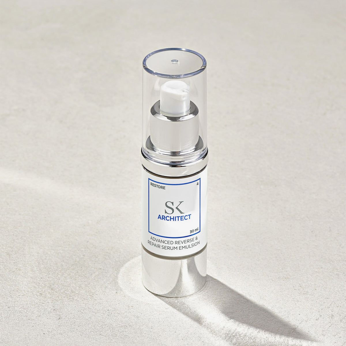 Skintegra Architect Serum in eleganter silber-weißer Pumpflasche mit Klarsichtdeckel, stehend auf hellem Untergrund mit Schattenwurf.