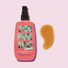 Eine rosa Flasche Rapid Watermelon Shimmer von The Fox Tan mit einem gelblichen Klecks auf rosa Hintergrund.