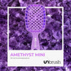 Große Version der UNbrush Glitter Duo Wet and Dry Detangling Brush von UNbrush auf einem Amethystkristall-Hintergrund abgebildet.