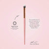 Der K21 Pack and Blend Brush mit rosa Griff, goldener Zwingen und weichen Borsten auf einem hellrosa Hintergrund.