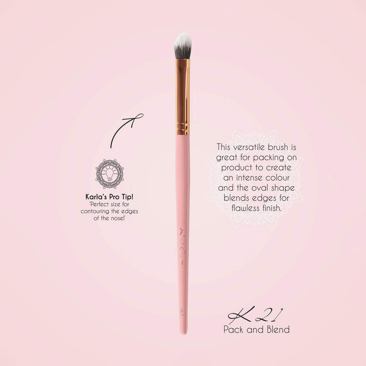 Der K21 Pack and Blend Brush mit rosa Griff, goldener Zwingen und weichen Borsten auf einem hellrosa Hintergrund.