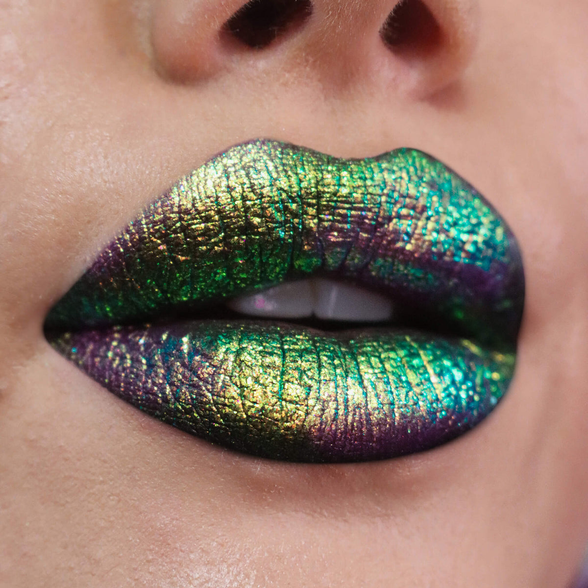 Nahaufnahme von Lippen, die mit dem Opal Moonstone Loose Multichrome Eyeshadow Boujee Bae geschminkt wurden und einen Grün-lilanen irisierenden Schimmer offenbaren.