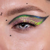 Nahaufnahme eines Auges mit dramatischem Eyeliner und gelb-grün schimmerndem Opal Moonstone Loose Multichrome Eyeshadow in Cry Baby.