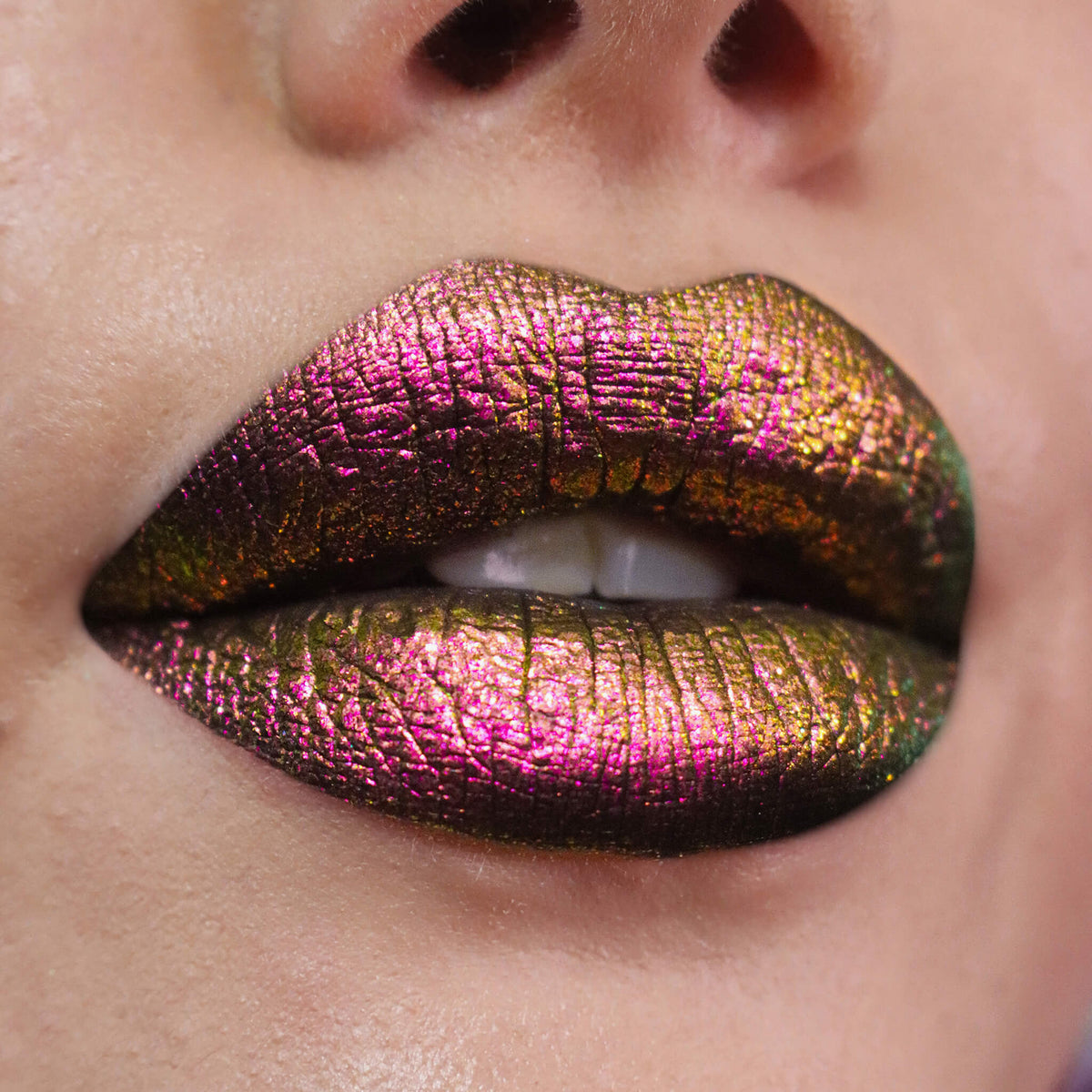 Nahaufnahme von Lippen, die mit dem Opal Moonstone Loose Multichrome Eyeshadow Drama Queen geschminkt wurden und einen rosa-goldenen irisierenden Schimmer offenbaren.
