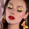 Frau mit dramatischem Eyeliner und glänzenden dunkelroten Lippen trägt gelb-grün schimmernden Opal Moonstone Loose Multichrome Eyeshadow in Sassy Pants auf den Augen.