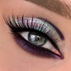 Nahaufnahme eines Auges mit dramatischem lilanen Eyeliner und grünlich-türkis schimmerndem Opal Multichrome Loose Eyeshadow in Chill.