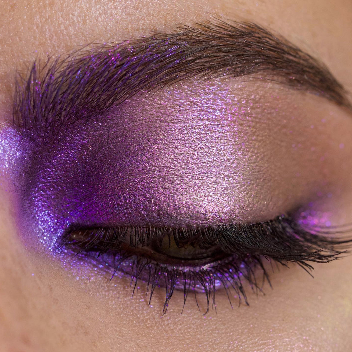 Nahaufnahme eines Auges mit dramatischem Make-up und lila schimmerndem Opal Multichrome Loose Eyeshadow in Insomnia.