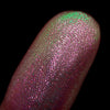 Nahaufnahme einer Fingerspitze, die in den Opal Multichrome Loose Eyeshadow Nightgown getaucht wurde und grün und rosa-bronze glitzert.