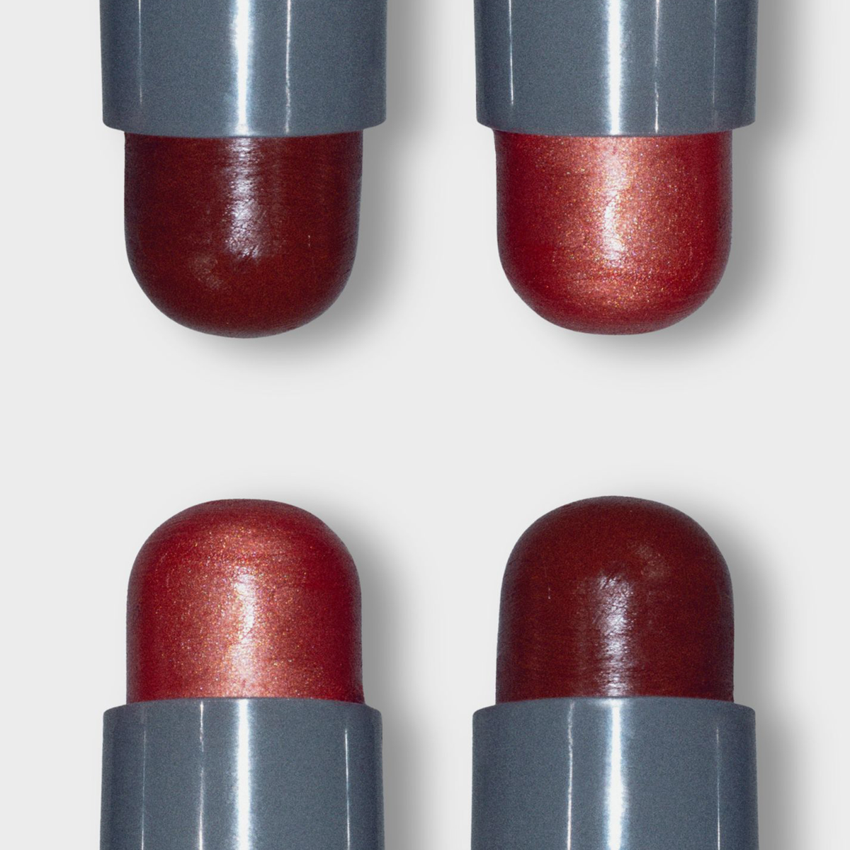 Vier LH Cosmetics Artistick Blush rote Metallic-Lippenstifte mit grauen Etuis, dargestellt in einem 2x2-Raster auf weißem Hintergrund.