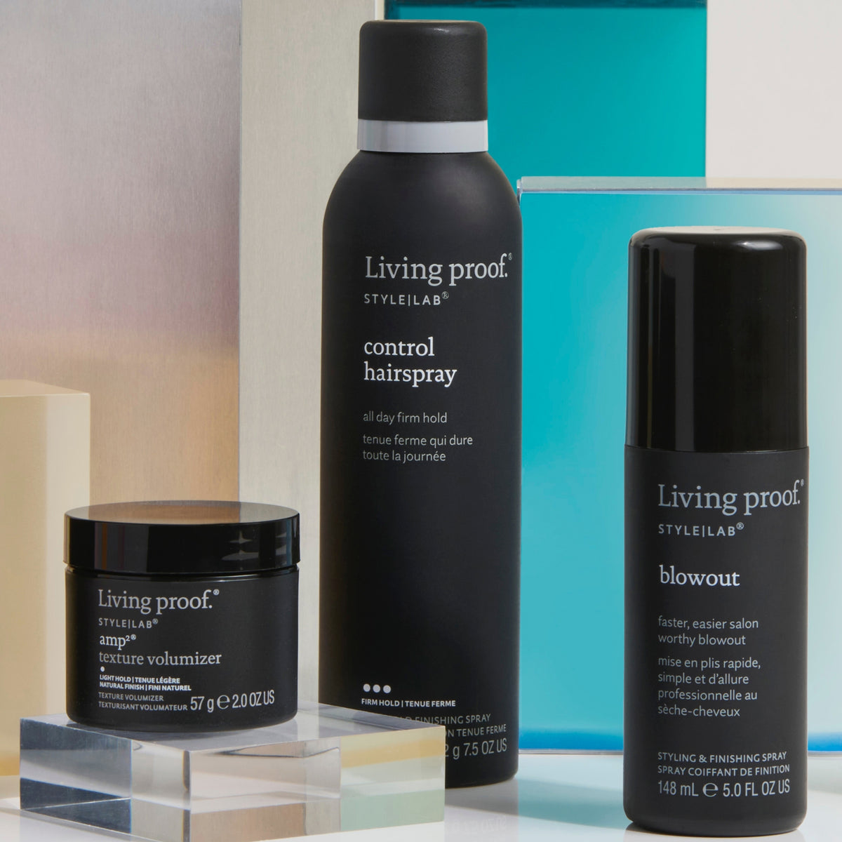 Living Proof Style Lab Flex Hairspray neben weiteren Styling Produkten vor lebendigen geometrischen Formen.