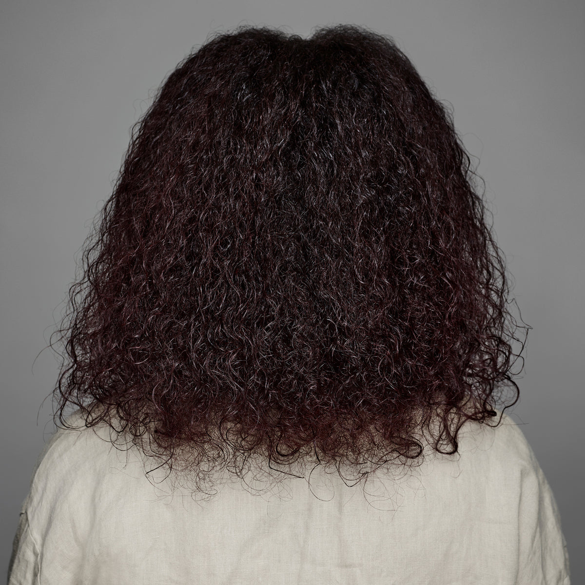 Eine Person von hinten zeigt gesunde Locken, die mit maria nila True Soft Shampoo gepflegt wurden.