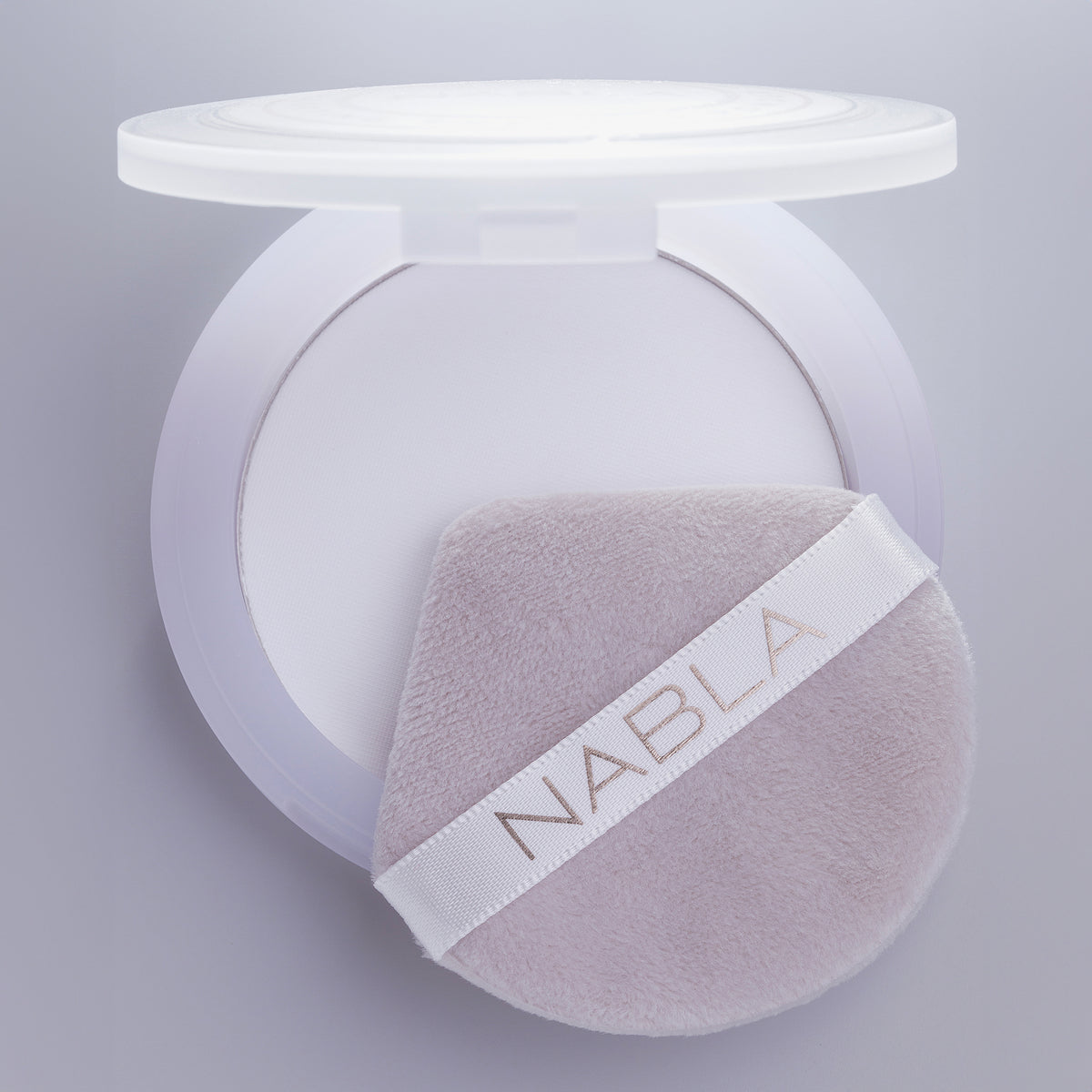 Nahaufnahme des Blotting Pressed Powder mit einem weichen, hellvioletten Applikator mit NABLA-Etikett darauf.