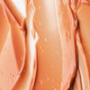 Nahaufnahme des glatten, glänzenden Pfirsichtons des Viper Delicious Lip Kit mit cremiger Textur, weichen, gewellten Streifen und leuchtenden Reflexen.