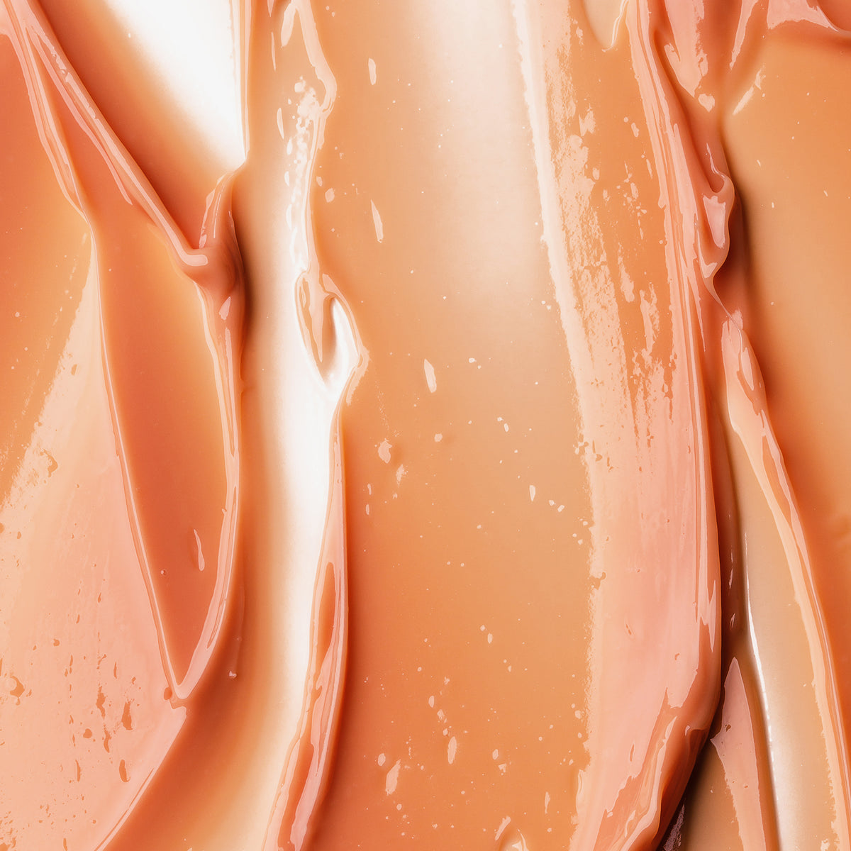 Nahaufnahme des glatten, glänzenden Pfirsichtons des Viper Delicious Lip Kit mit cremiger Textur, weichen, gewellten Streifen und leuchtenden Reflexen.