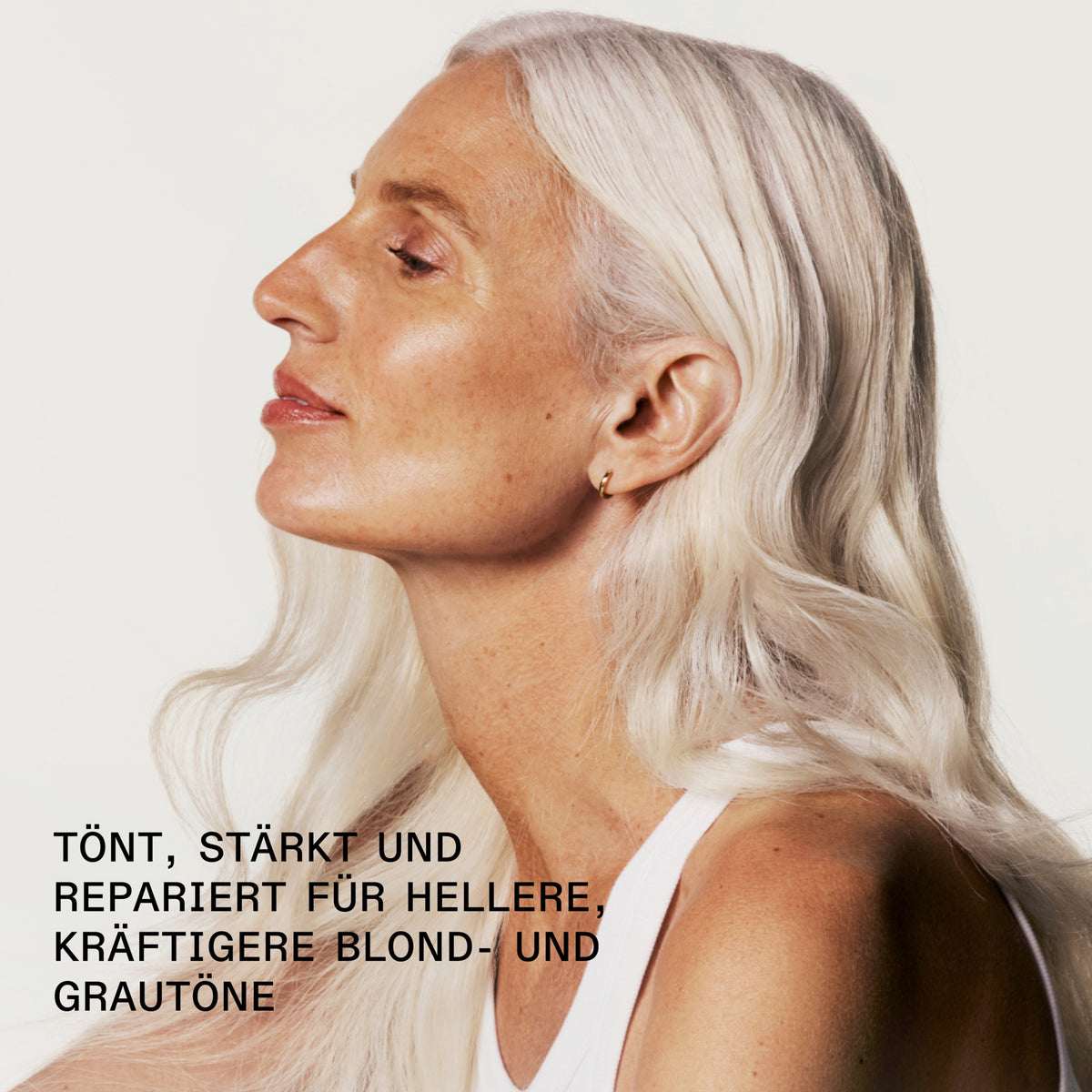 Eine gebräunte Fraun mit lichtblondem Haar; daneben der Text: "tönt, stärkt und repariert ür hellere, kräftigere Blond- und Grautöne."