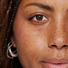 Nahaufnahme des Auges einer Person, der mit Brow Booster behandelten Augenbraue und der Wange.
