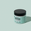 Ein rundes Töpfchen breakout+aid Breakout Body Scrub mit schwarzem Deckel und einem Etikett, auf dem Salicylsäure, Glykolsäure und Squalan aufgeführt sind.