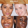 Vier Frauen mit unterschiedlichen Hauttönen, die alle mit strahlender, leuchtender Haut lächeln, präsentieren das Yummy Skin Glow Serum Main Squeeze von Danessa Myricks Beauty vor einem hellen Hintergrund.