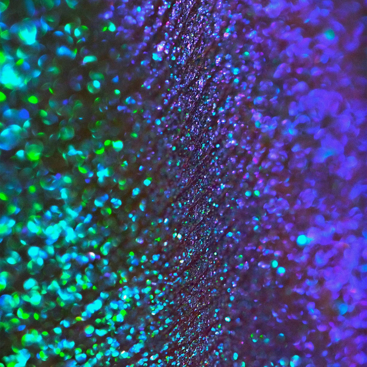 Nahaufnahme der Textur des Opal Moonstone Loose Multichrome Eyeshadow Clever Clogs; ein türkis-lila schimmerndes Pigment.