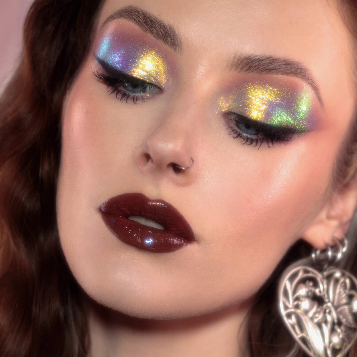 Frau mit dramatischem Eyeliner und glänzenden dunkelroten Lippen trägt gelb, grün und lila schimmernden Opal Moonstone Loose Multichrome Eyeshadow in Cry Baby auf den Augen.