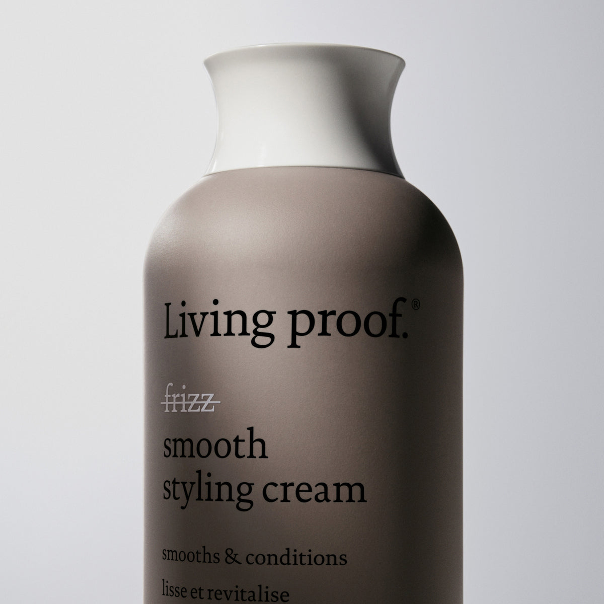 Eine Flasche Living Proof No Frizz Smooth Styling Cream vor einem schlichten, hellen Hintergrund.