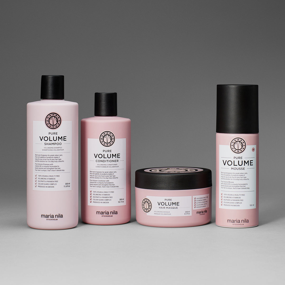 Vier rosafarbene maria nila Haarpflegeprodukte - Shampoo, Spülung, Pure Volume Masque und Schaumfestiger - sind auf einem grauen Hintergrund abgebildet.