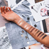 Ein Arm zeigt Swatches der ARCHETYPE Makeup-Palette von Mesauda Beauty über einer Collage aus Mode- und Schönheitsfotos.