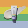 Eine Tube Celebrate Tøday All-In Barrier Cream ist auf einem pastellfarbenen Regenbogenhintergrund abgebildet, dahinter ein Klecks Creme.