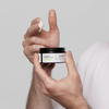 Hand entnimmt eine kleine Menge des Scandinavian Biolabs Flexible Hybrid Clay aus einer Dose.