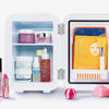 Geöffneter Beauty Fridge gefüllt mit Hautpflegeprodukten, Gesichtsmasken, Applikatoren, Lippenstift und Süßigkeiten.