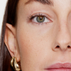Nahaufnahme des Auges einer Person mit langen, definierten Wimpern, die durch den XLASH Lash Booster betont werden.