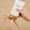 Eine Person drückt die SKIN1004 Madagascar Centella Cream aus der Tube auf ihren Handrücken.